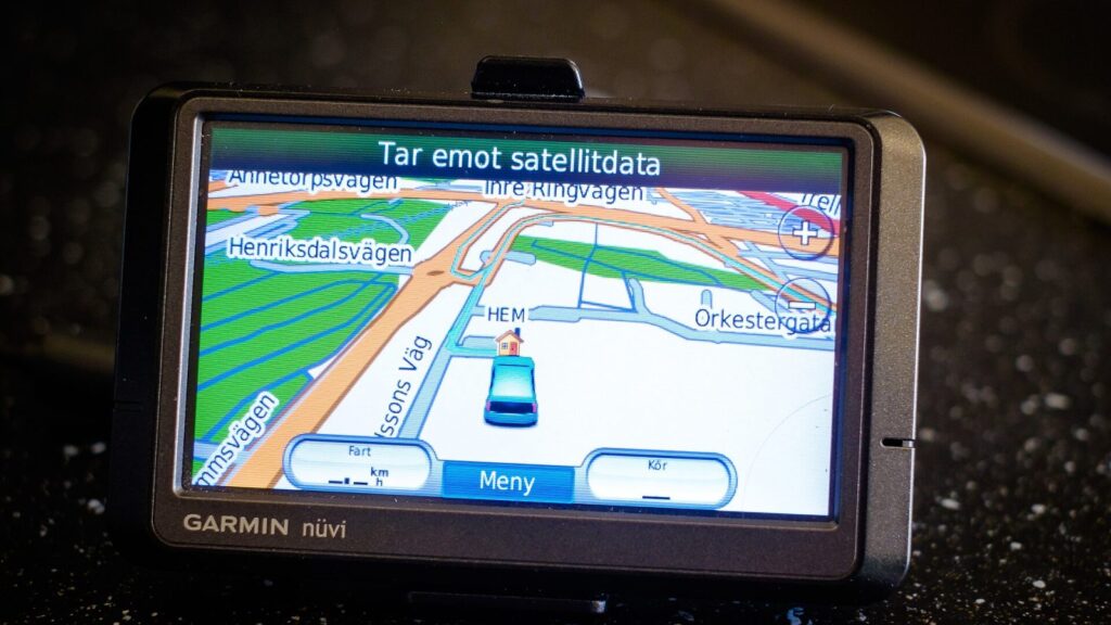 Senas juodas GPS navigatorius su mažu ekranu automobilio prietaisų skydelyje